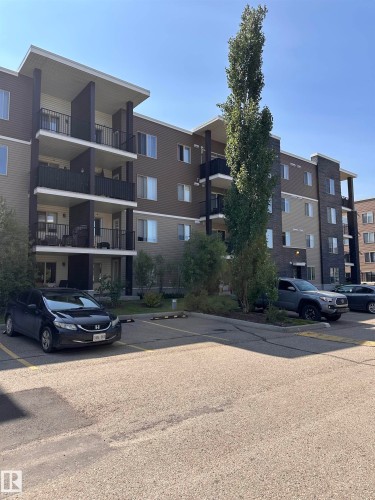 Multi-story building exterior featuring balconies with black railings, a mix of brown and beige siding, and multiple windows - #419 11808 22 Av Sw, Edmonton, AB - Outdoor With Balcony With Facade