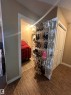 Dedicated laundry alcove featuring stacked appliances and wood-finish flooring - #419 11808 22 Av Sw, Edmonton, AB  - Indoor Photo Showing Other Room 