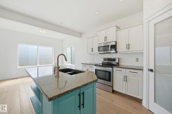 Kitchen featuring a central island with a dual-basin sink and an arched faucet - 