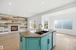 Open-concept living space featuring a central kitchen island with a double basin sink and granite countertop - 