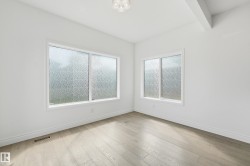 Room featuring light wood-finish flooring, white baseboards, and white walls - 