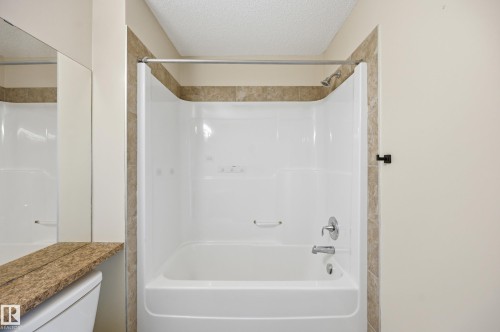 Tub and shower combination featuring an integrated white surround and polished chrome fixtures - 1 Southfork Close, Leduc, AB - Indoor Photo Showing Bathroom