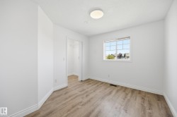 Room featuring wood-finish flooring, white walls, and a multi-pane window - 