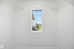 White-painted interior space featuring a single window with grids and white trim, offering exterior views - 