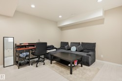 Recessed lighting illuminates this versatile space featuring light wood-finish flooring and neutral wall tones - 