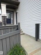 Vinyl siding exterior with stone accent column and covered entry - 