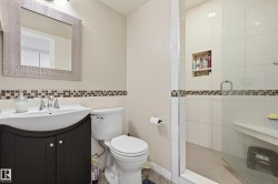 Shower with glass enclosure, integrated bench, and tiled niche - 