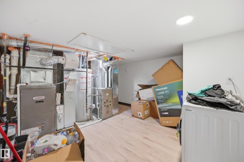 Utility area featuring a Lennox furnace, water heater, and wood-finish flooring - 1 Southfork Close, Leduc, AB - Indoor