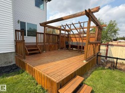 Expansive wood deck with a built-in pergola, privacy lattice, and integrated seating - 