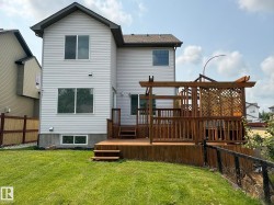 Rear exterior with light-colored siding and a dark roof - 