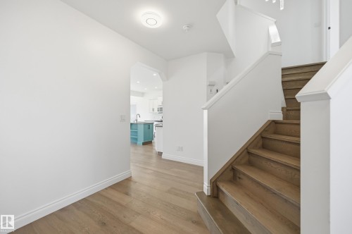 Hardwood staircase and flooring featuring white risers and baseboards - 1 Southfork Close, Leduc, AB - Indoor Photo Showing Other Room