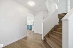 Hardwood staircase and flooring featuring white risers and baseboards - 