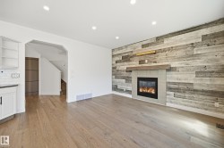 Living area featuring a reclaimed wood-style accent wall with a built-in fireplace and wood mantel - 