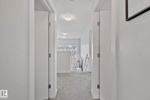 Hallway with white walls, light gray carpet, and white trim - 249 39A Avenue, Edmonton, AB - Indoor Photo Showing Other Room