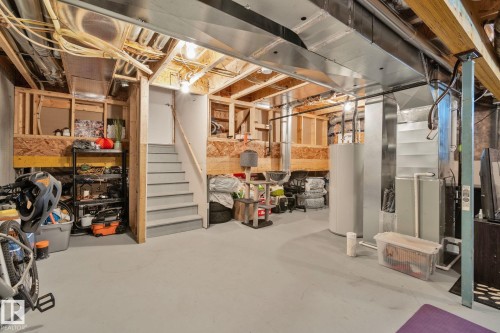 Unfinished basement featuring exposed wood framing, overhead ductwork, and a staircase with a wood handrail - 249 39A Avenue, Edmonton, AB - Indoor Photo Showing Basement