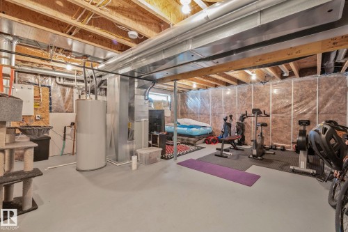 Unfinished basement featuring exposed wood joists, uninsulated walls, and a painted concrete floor - 249 39A Avenue, Edmonton, AB - Indoor Photo Showing Basement