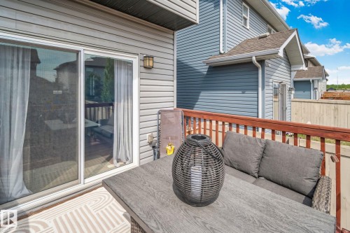 Private outdoor deck space featuring wood-finish railings, grey siding, and a sliding glass door - 249 39A Avenue, Edmonton, AB - Outdoor With Deck Patio Veranda With Exterior