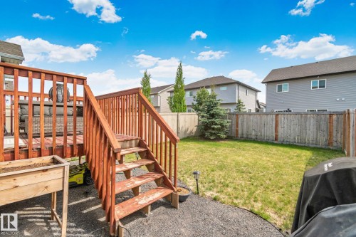 Expansive backyard featuring a wood deck with railings, natural wood stairs, a manicured lawn, and a wood privacy fence - 249 39A Avenue, Edmonton, AB - Outdoor