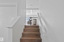 Wood-finish stair treads with white risers and handrails, leading to an upper level - 249 39A Avenue, Edmonton, AB  - Indoor Photo Showing Other Room 