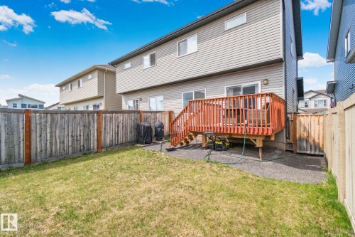 Rear yard featuring a wooden privacy fence, a raised wood deck with railing, and a ground-level patio area - 249 39A Avenue, Edmonton, AB - Outdoor With Deck Patio Veranda
