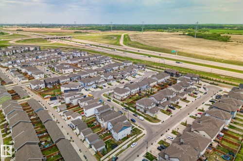 Aerial perspective showcasing a developed residential community with numerous single-family homes, each featuring brown or grey shingle roofs - 249 39A Avenue, Edmonton, AB - Outdoor With View