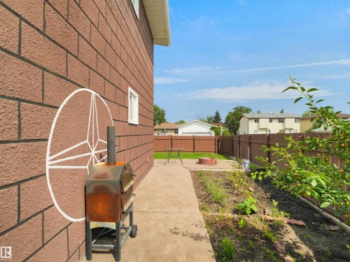 Exterior featuring textured brick-patterned siding and white trim windows - 15603 122 Street Nw, Edmonton, AB - Outdoor
