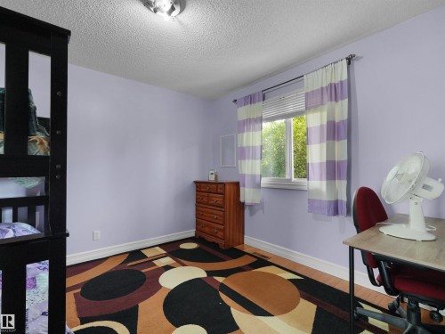Room featuring a single window, hard surface flooring, light purple wall paint, and a textured ceiling - 15603 122 Street Nw, Edmonton, AB - Indoor