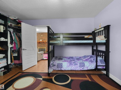 Bedroom featuring light purple walls and wood-finish flooring - 15603 122 Street Nw, Edmonton, AB - Indoor Photo Showing Bedroom