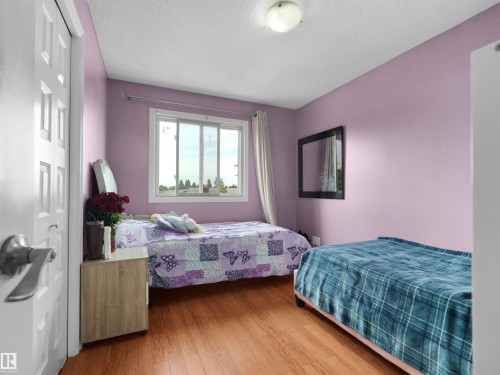 Interior room featuring wood-finish flooring and a white multi-pane window - 15603 122 Street Nw, Edmonton, AB - Indoor Photo Showing Bedroom