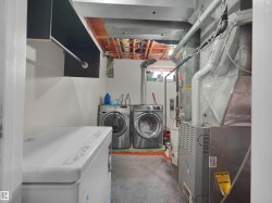 Laundry area featuring a built-in hanging rod, exposed ceiling joists, and utility access - 