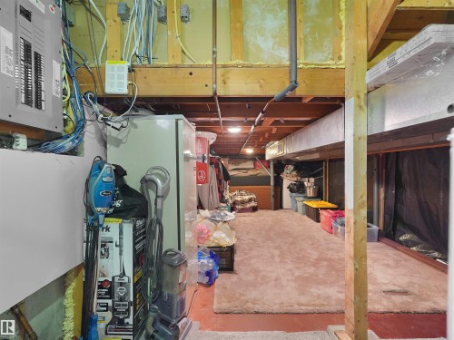 Unfinished basement space with exposed wooden joists and structural beams, featuring a utility panel and visible wiring - 15603 122 Street Nw, Edmonton, AB - Indoor Photo Showing Basement