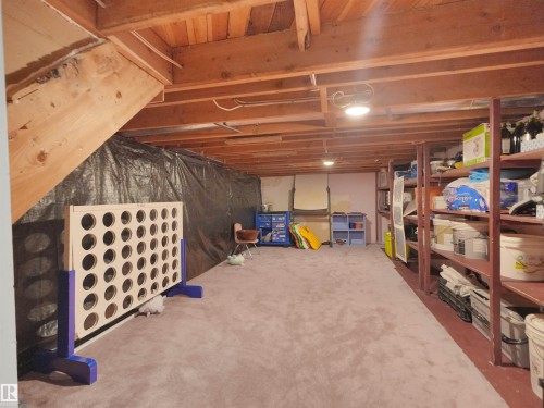 Carpeted room featuring exposed wood ceiling joists and integrated overhead lighting - 15603 122 Street Nw, Edmonton, AB - Indoor