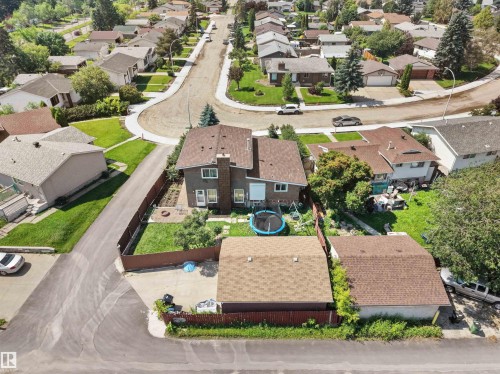 Two-story residence with a brown shingle roof, featuring a private fenced backyard with a patio area and mature landscaping - 15603 122 Street Nw, Edmonton, AB - Outdoor With View
