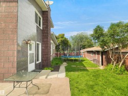 Expansive rear yard featuring green lawn space, a concrete patio, and a separate structure - 