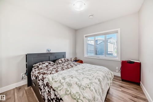 Neutral wall color in a room featuring wood-finish flooring - 2464 15 Avenue Nw, Edmonton, AB - Indoor Photo Showing Bedroom