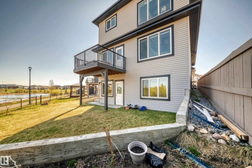 Three-story residence featuring light gray siding, dark trim, and a second-story deck with black railings - 2464 15 Avenue Nw, Edmonton, AB - Outdoor With Exterior