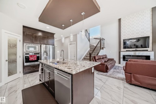 Open-concept living space with large format tile flooring - 2464 15 Avenue Nw, Edmonton, AB - Indoor Photo Showing Kitchen With Double Sink With Upgraded Kitchen