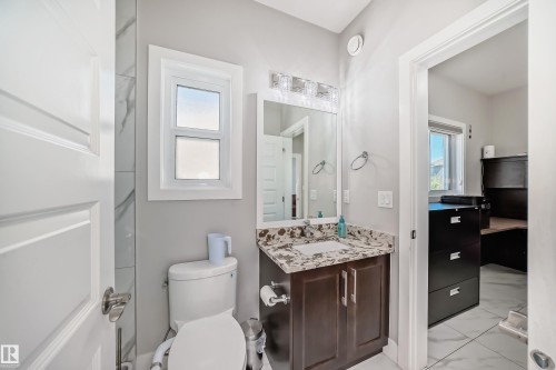 Bathroom featuring a dark wood-finish vanity with a stone countertop and an under-mount sink - 2464 15 Avenue Nw, Edmonton, AB - Indoor Photo Showing Bathroom