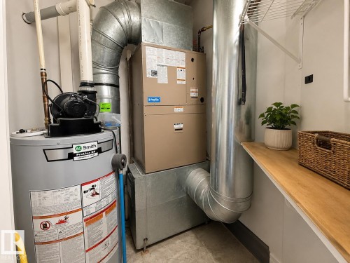 Utility closet featuring a water heater, furnace, and exposed galvanized steel ductwork - #412 9503 101 Av Nw, Edmonton, AB - Indoor Photo Showing Basement