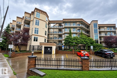Contemporary multi-story building featuring a beige exterior with stone accents and multiple balconies - #412 9503 101 Av Nw, Edmonton, AB - Outdoor With Balcony With Facade