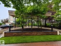 Exterior showcasing a covered entryway with building numbers 9503 and 9507, framed by a decorative black metal fence - #412 9503 101 Av Nw, Edmonton, AB  - Outdoor 