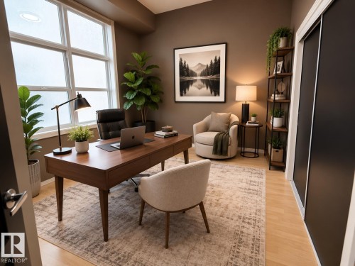 Dedicated room featuring large window, wood-finish flooring, a built-in closet with dark sliding doors, and ample space for a desk and seating - #412 9503 101 Av Nw, Edmonton, AB - Indoor