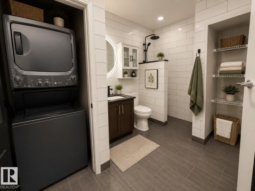 Modern bathroom featuring a stacked washer and dryer, wood-finish flooring, white subway tile walls, a dark wood vanity with a vessel sink, and an illuminated circular mirror - #412 9503 101 Av Nw, Edmonton, AB - Indoor Photo Showing Laundry Room