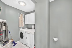 Dedicated laundry space featuring a front-load washing machine and top-load dryer - 