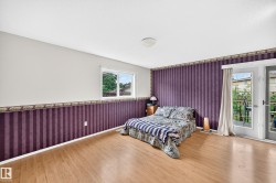 Room featuring wood-finish flooring, a double window, and French doors opening to an exterior deck - 
