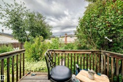 Wood deck featuring wood railing and lush surrounding foliage - 