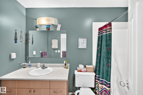 Bathroom featuring a vanity with a laminate countertop, an oval sink, and wood-finish cabinetry - 1116 39 Street Nw, Edmonton, AB - Indoor Photo Showing Bathroom