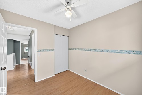 Interior room featuring wood-finish flooring, light neutral wall paint, and a ceiling fan with integrated lighting - 1116 39 Street Nw, Edmonton, AB - Indoor Photo Showing Other Room