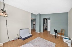Bright interior space featuring wood-finish flooring, two-tone wall paint, and white trim molding - 