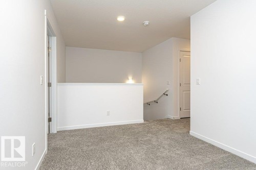 Upper-level landing featuring textured gray carpeting, white painted walls, and recessed lighting - 6269 175A Avenue Nw, Edmonton, AB - Indoor Photo Showing Other Room